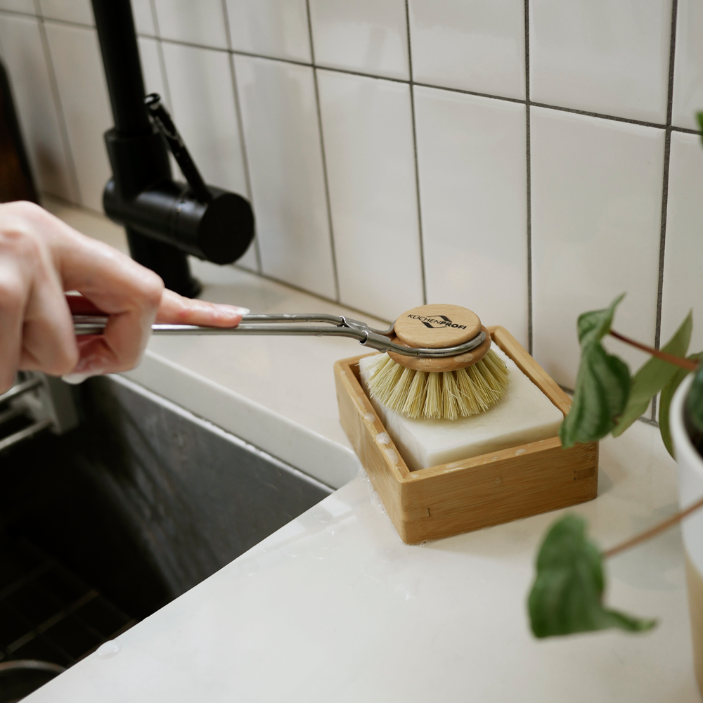 The-Good-Fill-Dishwashing Block sitting in a bamboo dish shelf