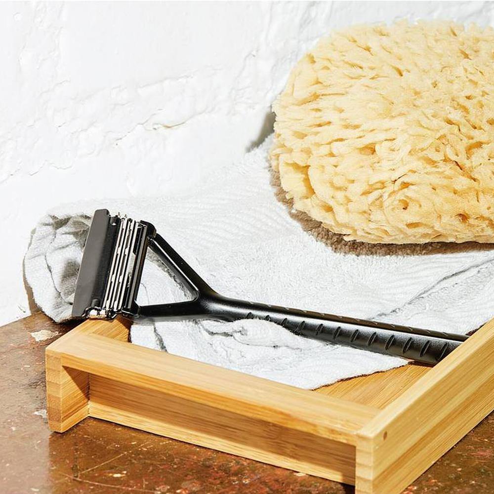 Matte Black Pivoting Triple Blade Razor. The razor is sitting on a white bathroom towel.