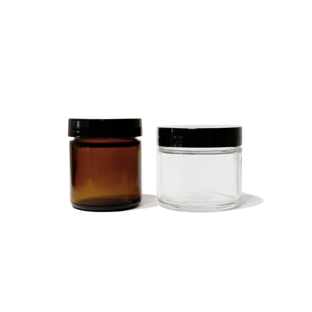 one amber 2oz glass jar with black lid and one clear 2oz glass jar with black lid.