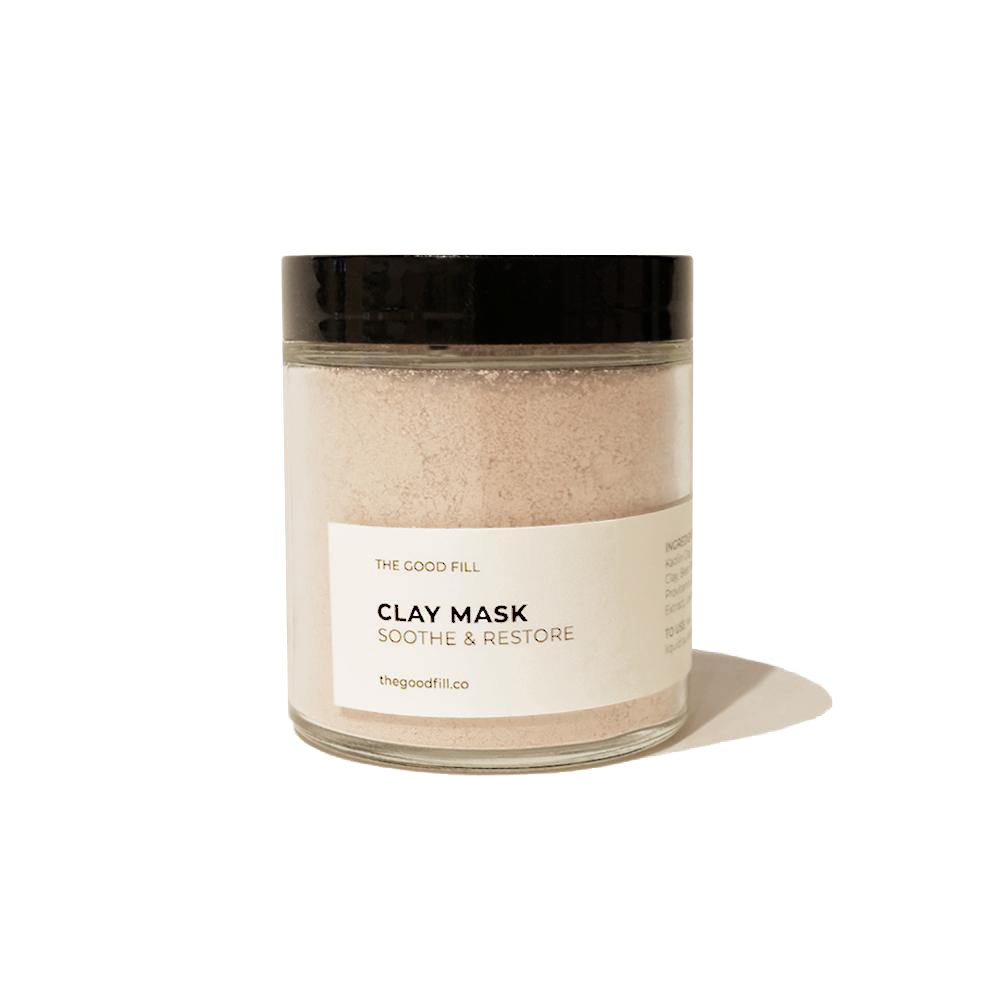 4oz. re-usable clear Good Fill glass jar filled with a light pink clay mask powder. The lid is a black twist-on lid.