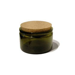 4oz. round recycled glass jar with a cork lid top. The jar is round and painted a dark olive green color.