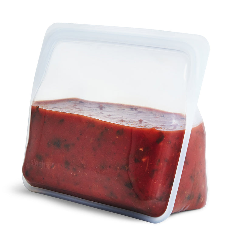 a reusable, zero waste clear stand-up stasher bag. The bag is holding tomato soup.