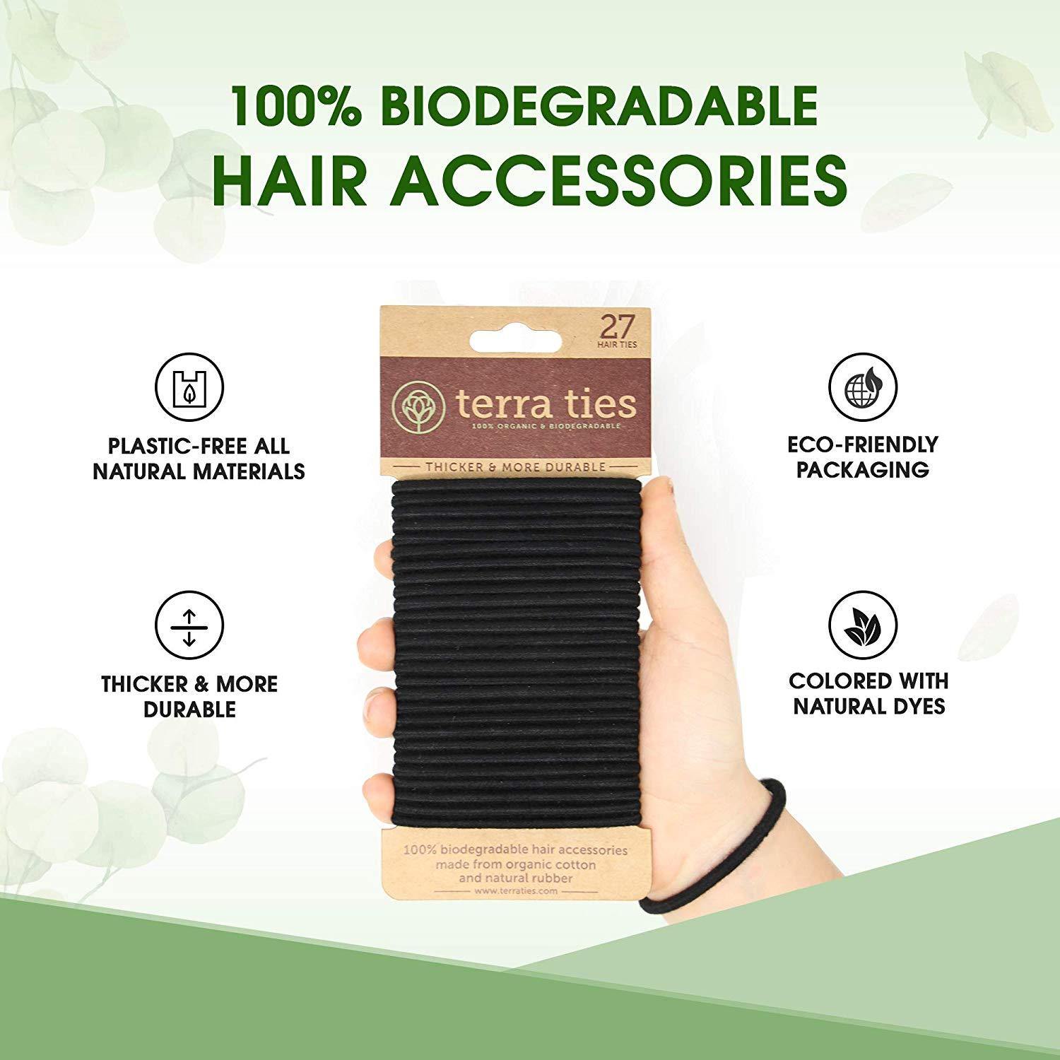 hand holding a pack of 27 black hair ties - featuring that they are 100% biodegradable, natural dies, and plastic free