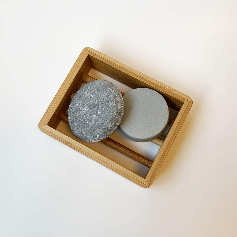 product shot of brown, rectangle bamboo soap dish holding our package free shampoo and conditioner bars