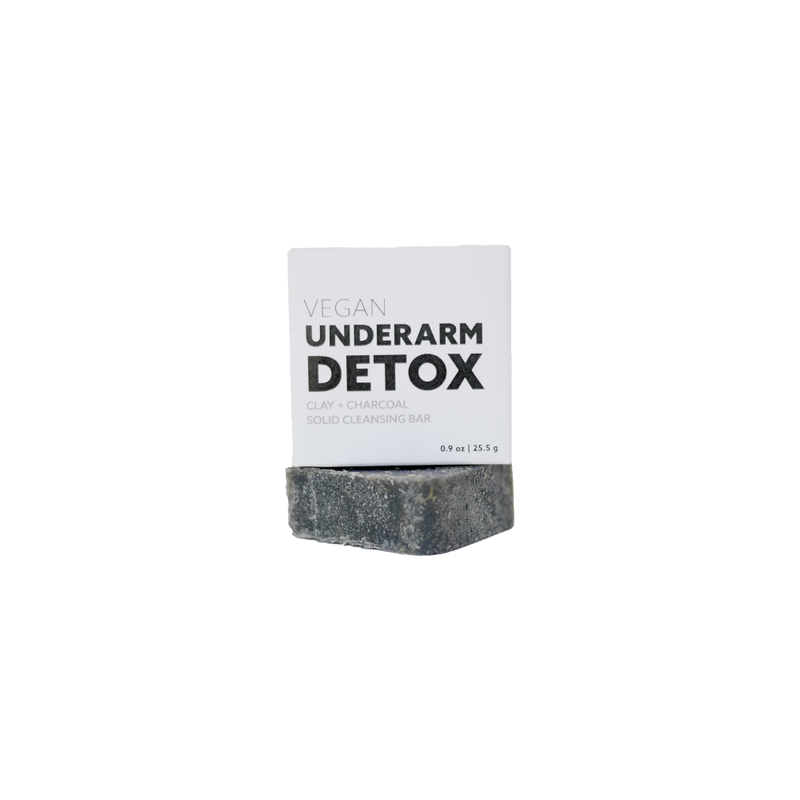 charcoal colored, square underarm detox bar. There is a white recyclable packaging box with black bold print.