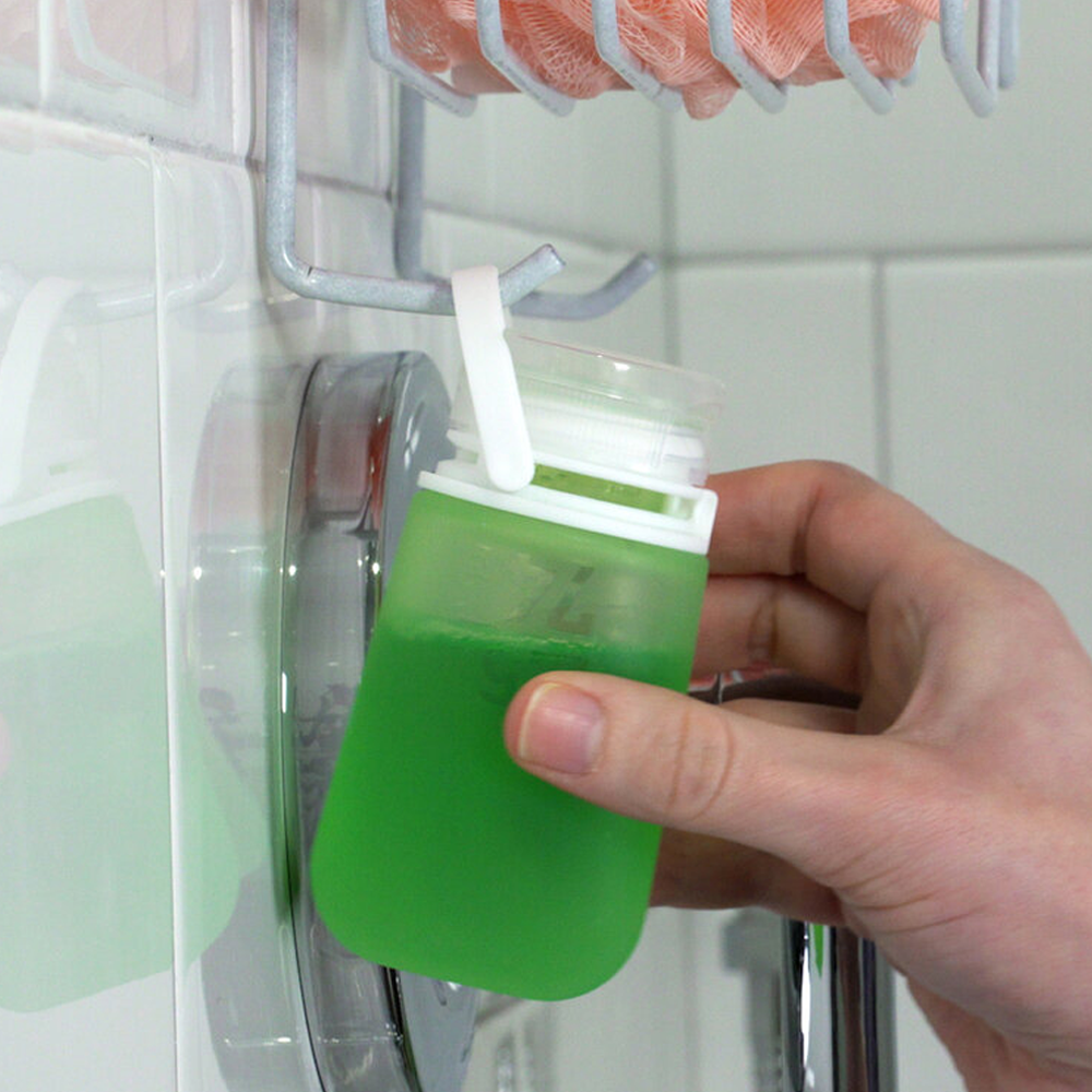 A GoToob filled with body wash and hanging in the shower by its loop lock.