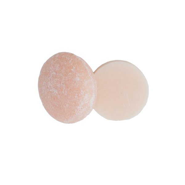 one round Lavender Cedar shampoo bar and one round Lavender Cedar conditioner bar on a white background. The bars are a light pink color and are zero waste and package free.