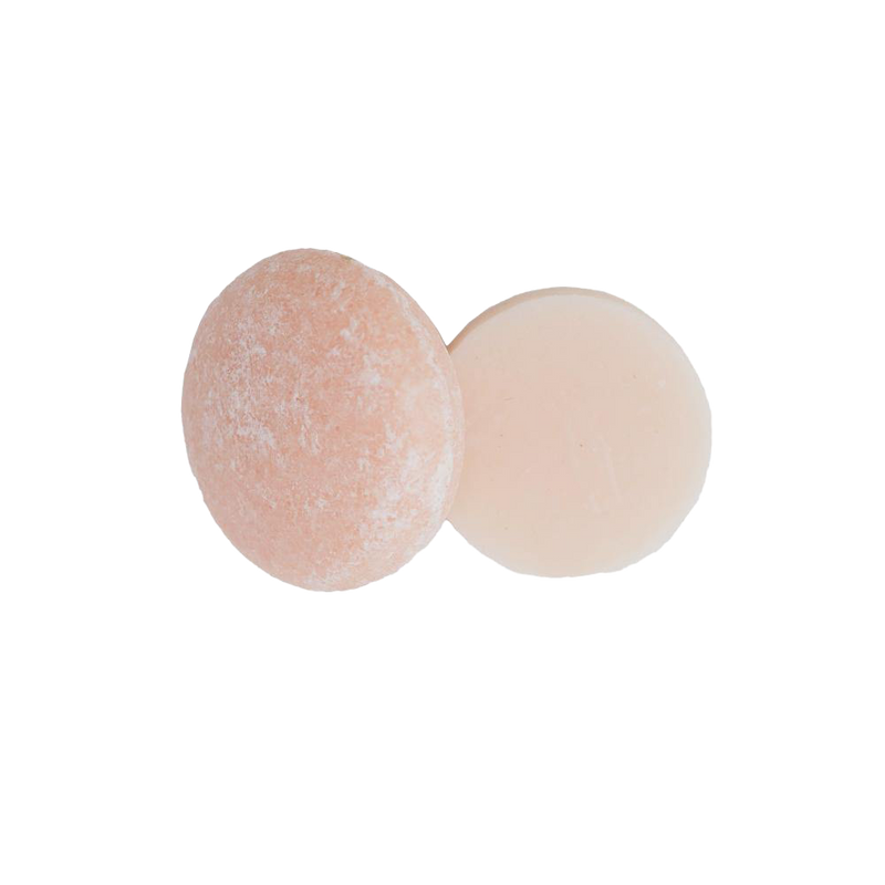 one round Lavender Cedar shampoo bar and one round Lavender Cedar conditioner bar on a white background. The bars are a light pink color and are zero waste and package free.