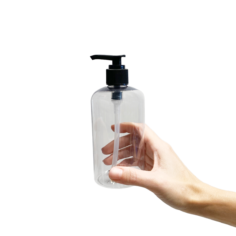 Hand holding a 12oz clear recycled plastic bottle with a black pump top