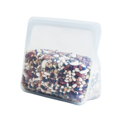a reusable, zero waste clear stand-up stasher bag. The bag is holding an assortment of uncooked dry beans.